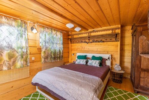 a bedroom with a bed in a wooden room at Domek Rożnów 2 in Rożnów