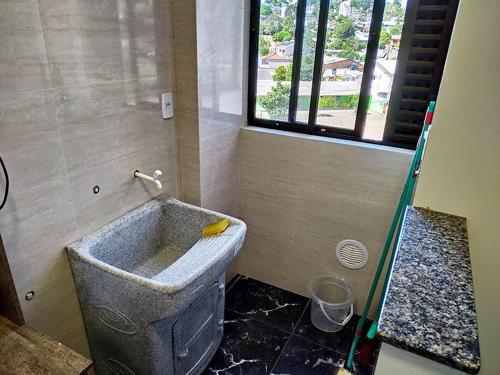 ein Badezimmer mit Badewanne und Fenster in der Unterkunft Edifício Louise – Apto 301 in Chapecó