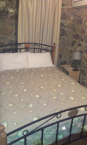 a bed in a room with a stone wall at Patriko Traditional House in Kakopetria