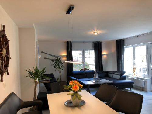 a living room with a blue couch and a table at Haus Frauken in Grömitz