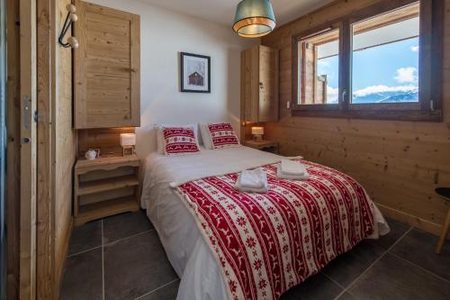 - une chambre dotée d'un lit avec une couverture rouge et blanche dans l'établissement Appartement moderne et chaleureux sur les pistes, à La Toussuire