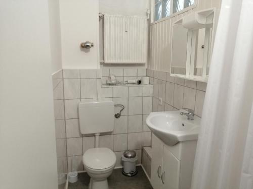 biała łazienka z toaletą i umywalką w obiekcie Wohnung in Köln 2B w Kolonii