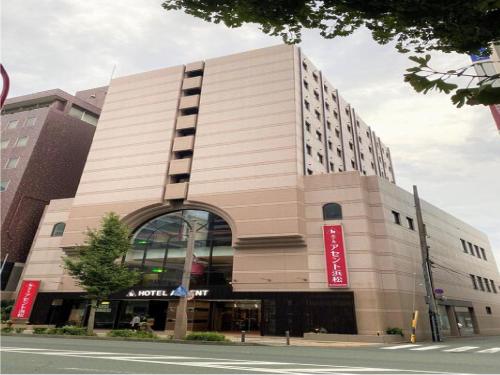 a large building with a red sign on it at Hotel Ascent Hamamatsu / Vacation STAY 79774 in Hamamatsu