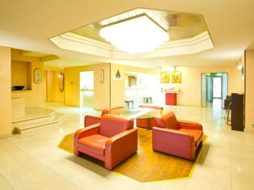 a living room with orange chairs and a table at Hotel Ascent Hamamatsu / Vacation STAY 79774 in Hamamatsu