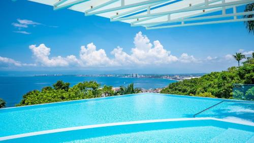 a swimming pool with a view of the ocean at Avalon - 401 Luxury & Breathtaking Sunset Views in Puerto Vallarta