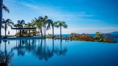 a large swimming pool with palm trees and a gazebo at Paramount Bay - 308 Peaceful Luxury View 2 BR in Puerto Vallarta