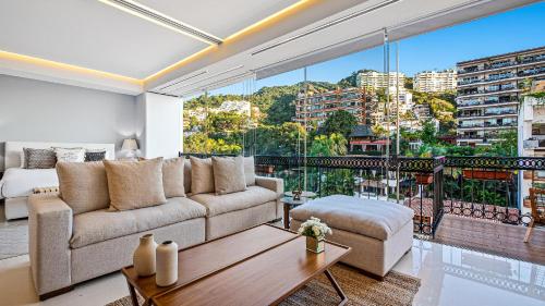 a living room with a couch and a large window at PIER 57 - 609 2 BR Amazing Roof in Romantic Zone in Puerto Vallarta