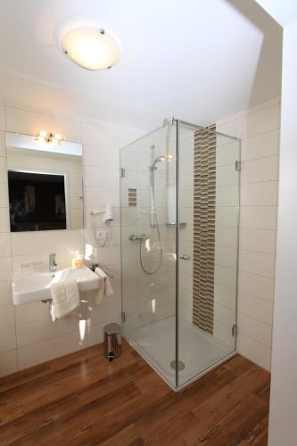 a bathroom with a glass shower and a sink at Hotel - Restaurant Eberlwirt in Bruckberg