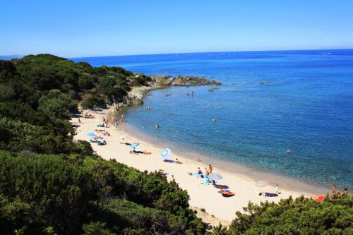 a group of people on a beach with umbrellas at Dimore Dell'Isola Rossa in Isola Rossa