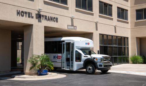 a white bus parked in front of a building at NCED Conference Center & Hotel in Norman