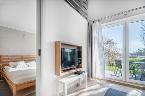 グダニスクにあるCITYSTAY miniLOFT Gdanskのベッドルーム(ベッド1台、テレビ、窓付)