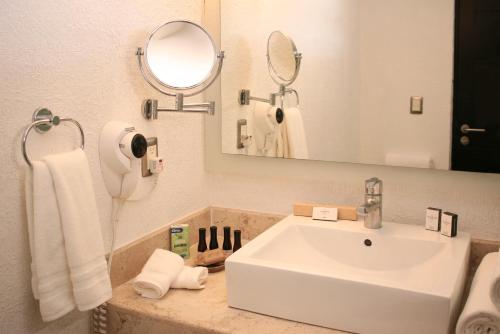 a bathroom with a white sink and a mirror at Hotel Rio Tequisquiapan in Tequisquiapan