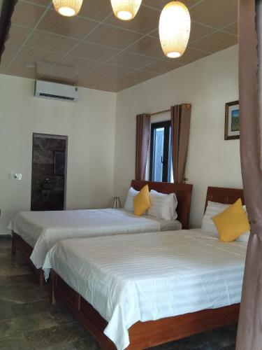 a bedroom with two beds and two lamps at The Natural Bungalow in Hoi An