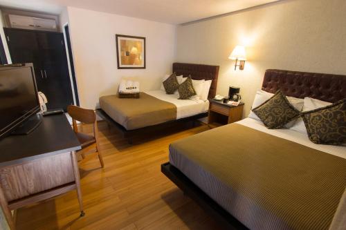 a hotel room with two beds and a flat screen tv at Hotel Rio Tequisquiapan in Tequisquiapan