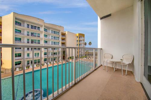 a balcony with a swimming pool and two buildings at Peninsula Island Resort & Spa - Beachfront Property at South Padre Island in South Padre Island