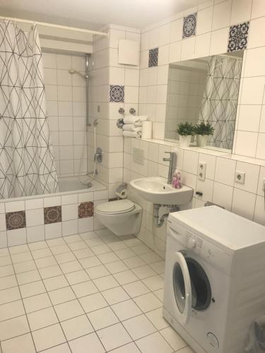 Un baño con lavadora y un inodoro. en Baynunah Suites Aparthotel, en Múnich