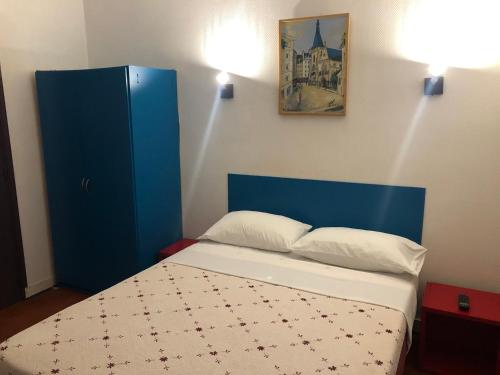 ルヴァロワ・ペレにあるホテル シュヴァリエのベッドルーム(青いキャビネット、ベッド付)
