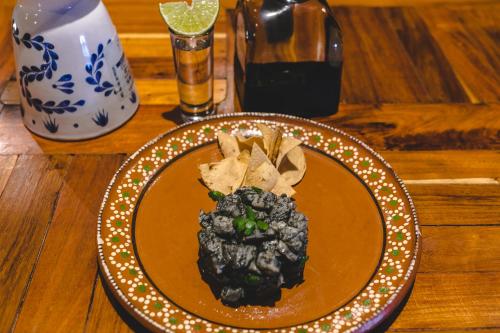 a plate of food on top of a wooden table at Hotel Boutique La Puerta Azul Beachfront - Adults Only in Holbox Island