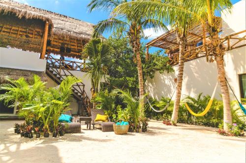 a resort with palm trees and a building at Hotel Boutique La Puerta Azul Beachfront - Adults Only in Holbox Island
