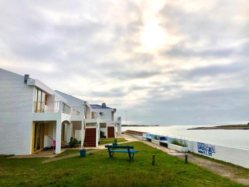 una casa con una mesa de picnic junto al océano en Apartamentos Alborada, en La Paloma