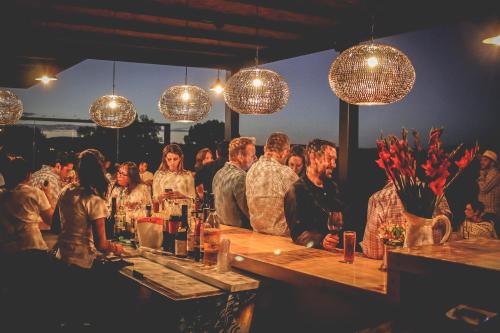 a group of people standing at a bar with lights at Hotel Rio Tequisquiapan in Tequisquiapan