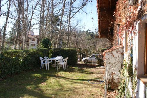 a table and chairs in the yard of a house at Cabañas Am Hang in La Cumbrecita