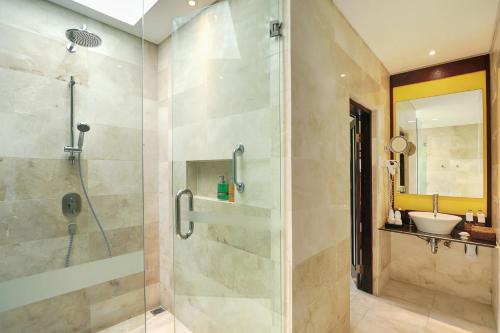 a bathroom with a shower and a sink at Legian Beach Hotel in Legian