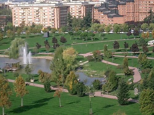 a park with a fountain and a pond in a city at Gestión de Alojamientos Rooms in Pamplona