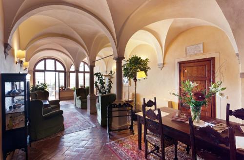 a living room with a table and chairs at Palazzo Leopoldo Dimora Storica & Spa in Radda in Chianti