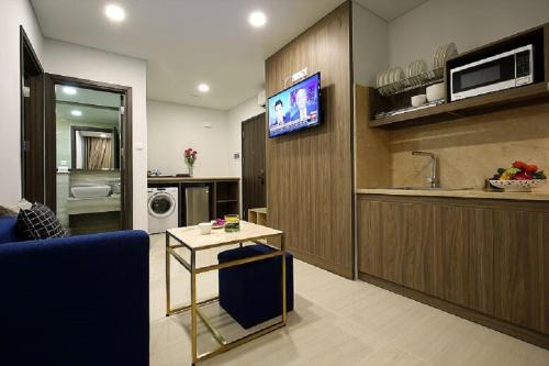 a living room with a blue couch and a kitchen at Aurora Western Village in Ho Chi Minh City