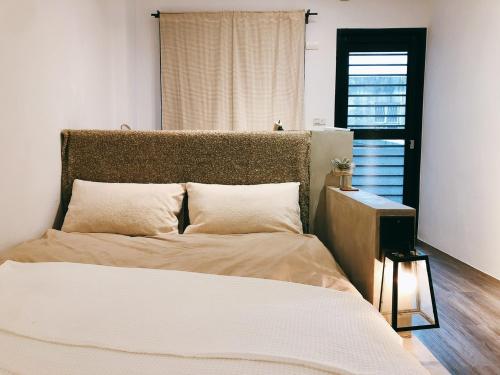 a bedroom with a bed and a window at 歸宿back home in Tainan