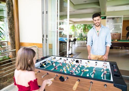 a young girl and a man standing next to a pool table at Jpark Island Resort & Waterpark Cebu in Mactan