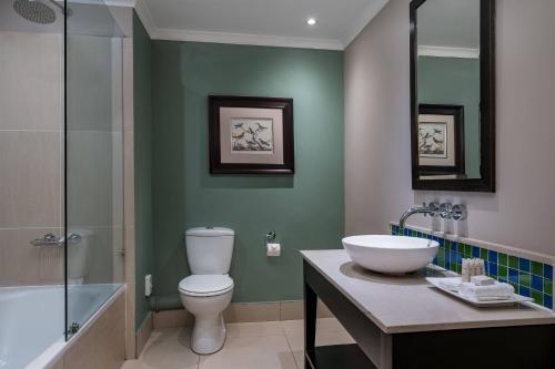 a bathroom with a toilet and a sink and a shower at Mount Grace Hotel & Spa in Magaliesburg