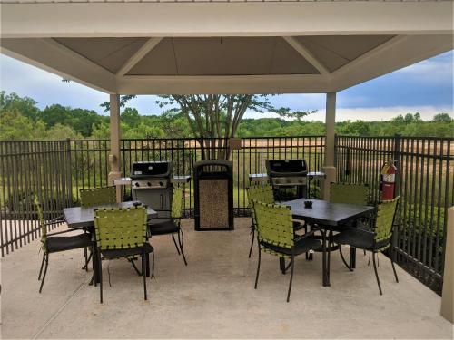 a patio with tables and chairs and a grill at Candlewood Suites Macon by IHG in Macon