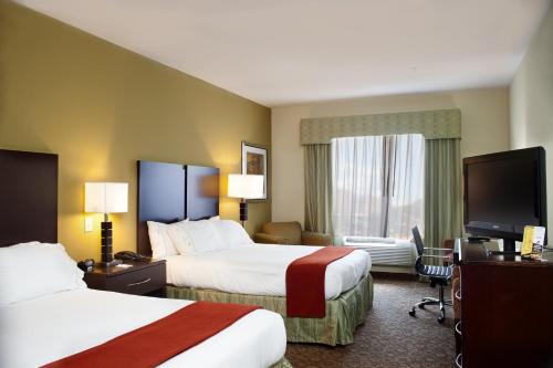 a hotel room with two beds and a flat screen tv at Holiday Inn Express Hotel & Suites Waller by IHG in Waller