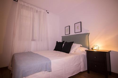 une chambre avec un lit blanc et une fenêtre dans l'établissement Bajo Izq, à Tolède