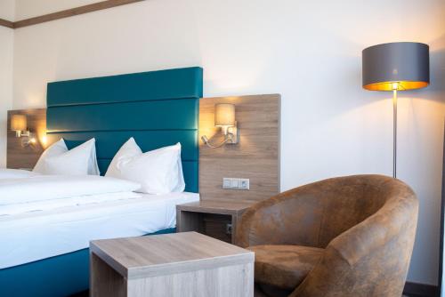 ein Hotelzimmer mit einem Bett und einem Stuhl in der Unterkunft Hotel Metropol in Sankt Pölten