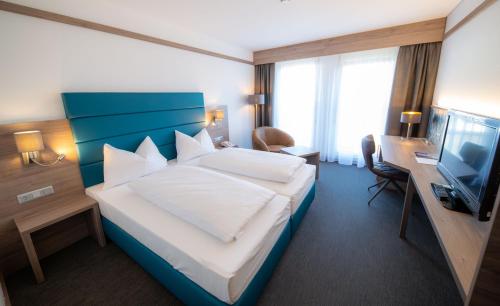 ザンクト・ペルテンにあるホテル メトロポールのベッドとテレビが備わるホテルルームです。