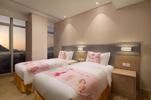 two beds with hello kitty pillows in a bedroom at Holiday Inn Express Qingdao Innovation Park by IHG in Qingdao