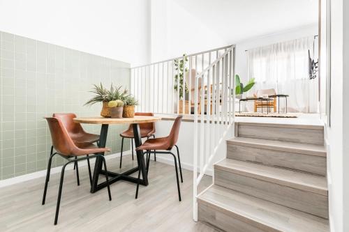 uma sala de jantar com mesa, cadeiras e escadas em Cool Apartments by Olala Homes em Madrid