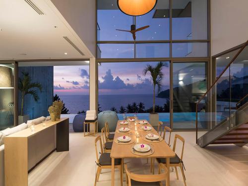 a dining room with a table and a view of the ocean at Malaiwana Residences in Nai Thon Beach