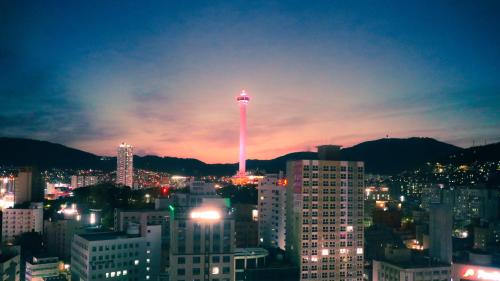 a view of a city at night with a tower at Connect Busan Hotel & Residence in Busan