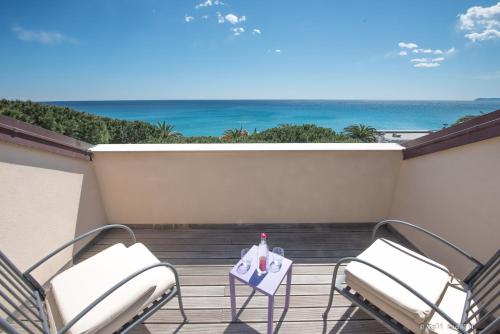 a balcony with two chairs and a table and the ocean at Hotel San Pietro Palace in Finale Ligure