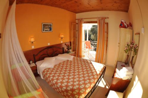 - une chambre avec un grand lit et un balcon dans l'établissement Paraskevi Apartments, à Paleokastritsa
