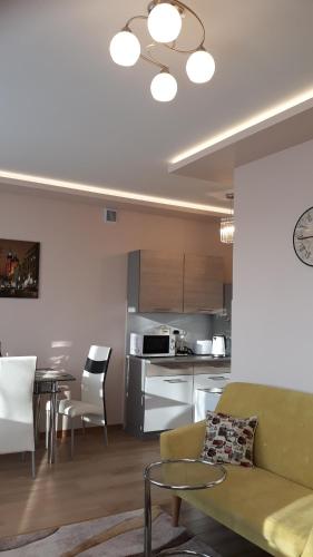 een woonkamer en een keuken met een bank en een tafel bij Piast Apartament in Krakau