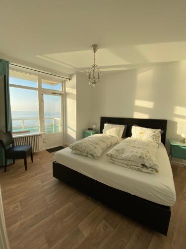 a bedroom with a bed and a large window at Berrie's Sea View in Zandvoort