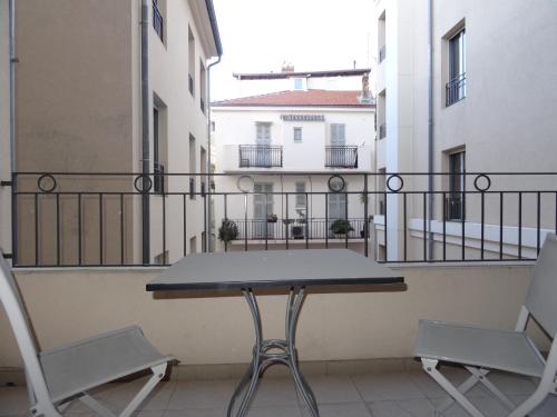 a table and chairs on a balcony with buildings at Le Vieux Port Apartments in Cannes