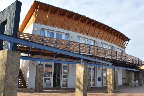a house with a large deck on top of it at Sekli Panzió in Balatonlelle