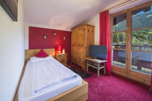 a bedroom with a bed and a television in it at Hotel Gamshof in Kitzbühel