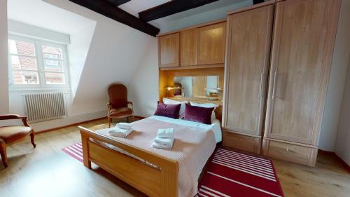 um quarto com uma cama com almofadas roxas em Aux Bijoux de Colmar - Le Saphir - 1 PARKING GRATUIT em Colmar
